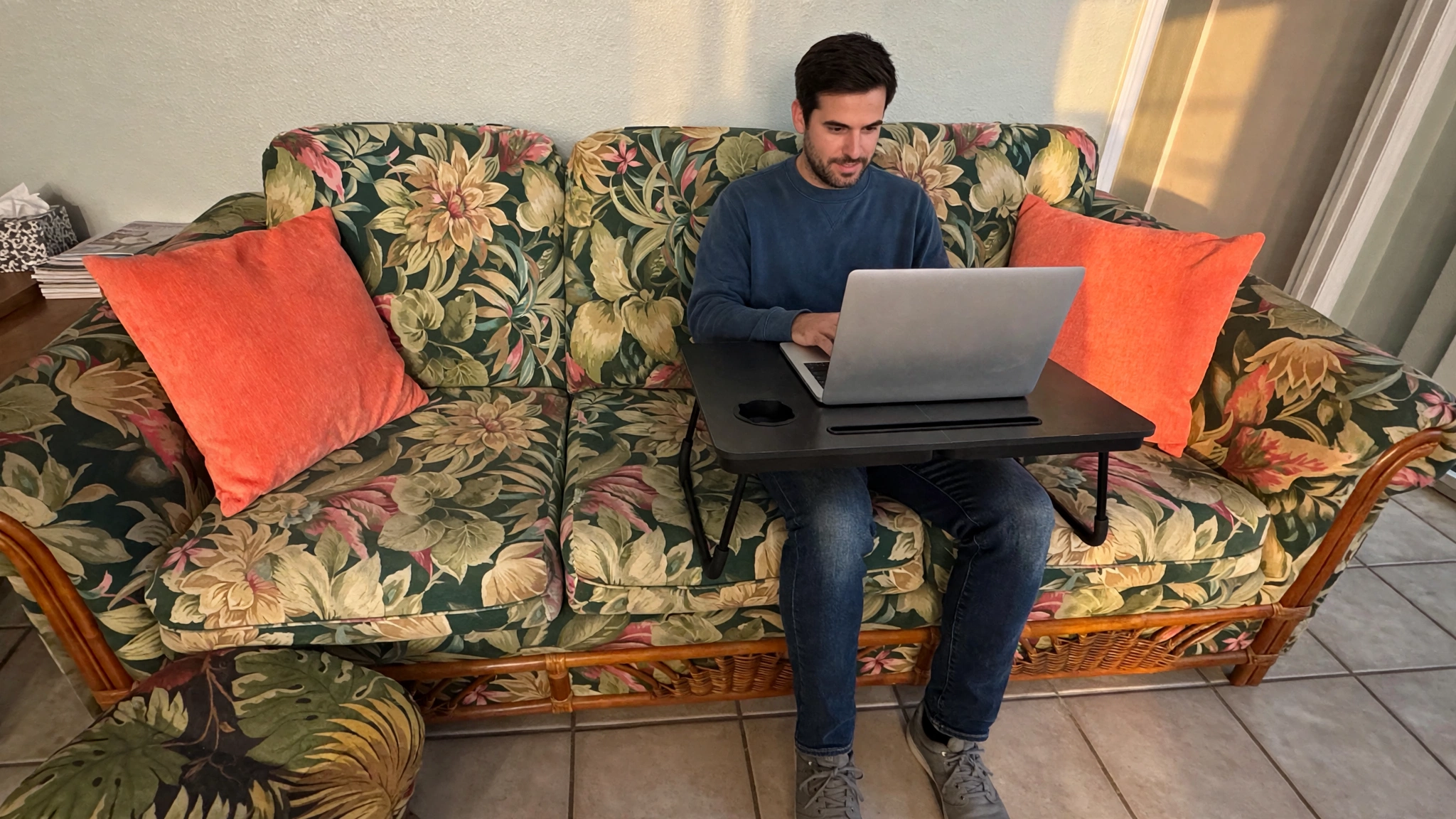 Remote worker on the couch using the provided lap desk in the St. Pete Beach condo